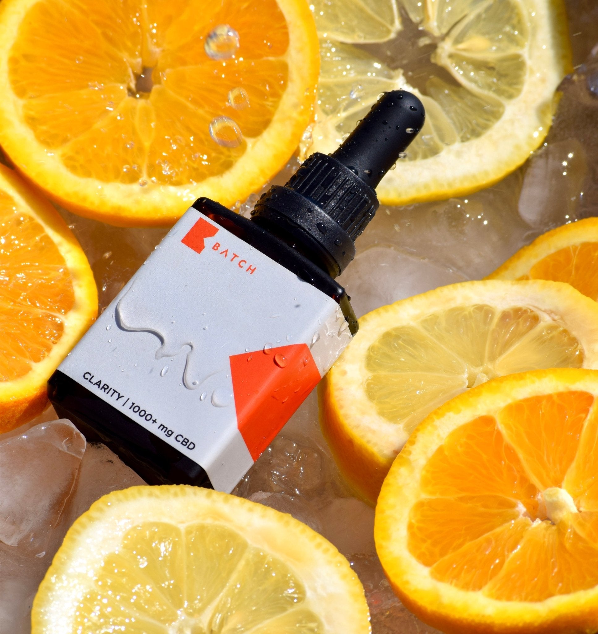 tincture bottle in water with citrus fruit slices