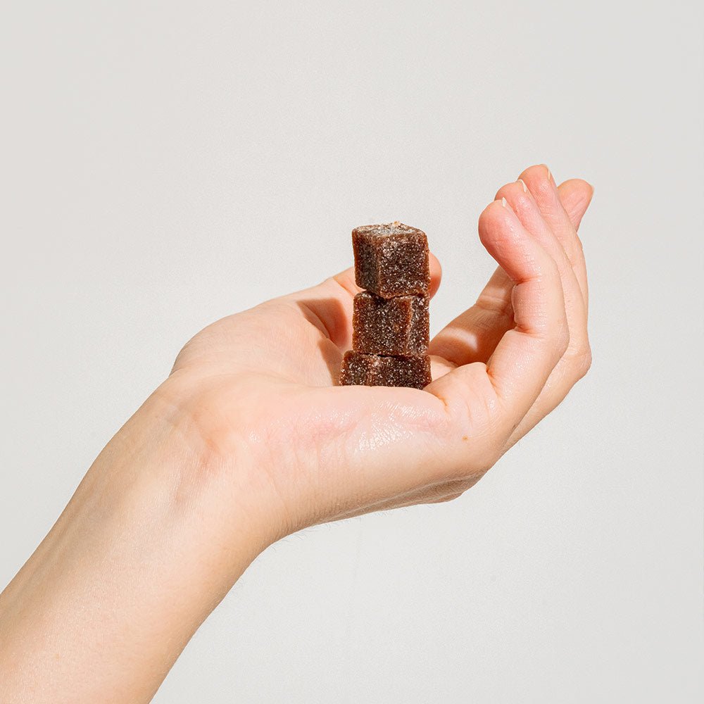 3 brain boost gummies stacked in a hand