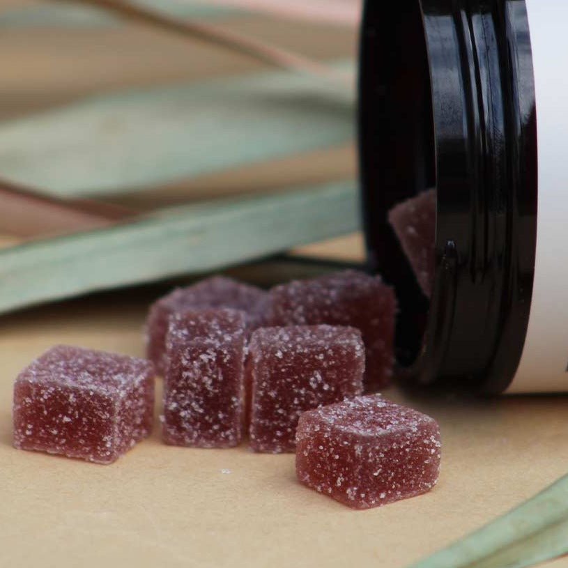 handful of  all natural sleep inducing all-natural gummies spilling out of container